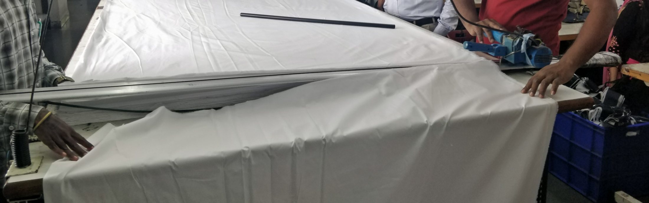 Cutting layered white linen fabric