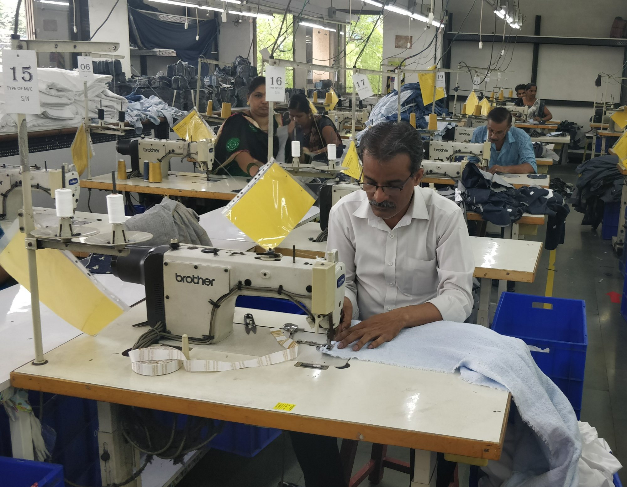 Hands guiding a hem under the sewing needle