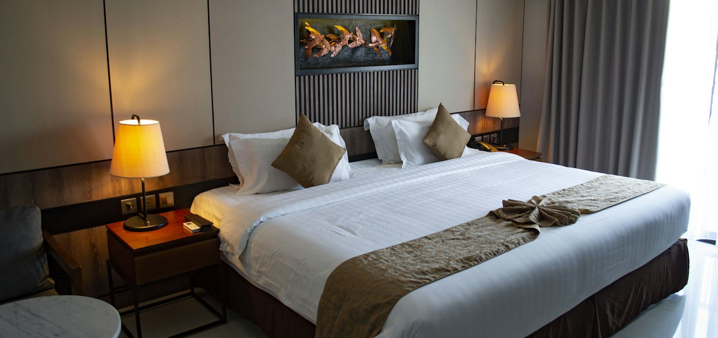 Made bed with crisp white bed linen